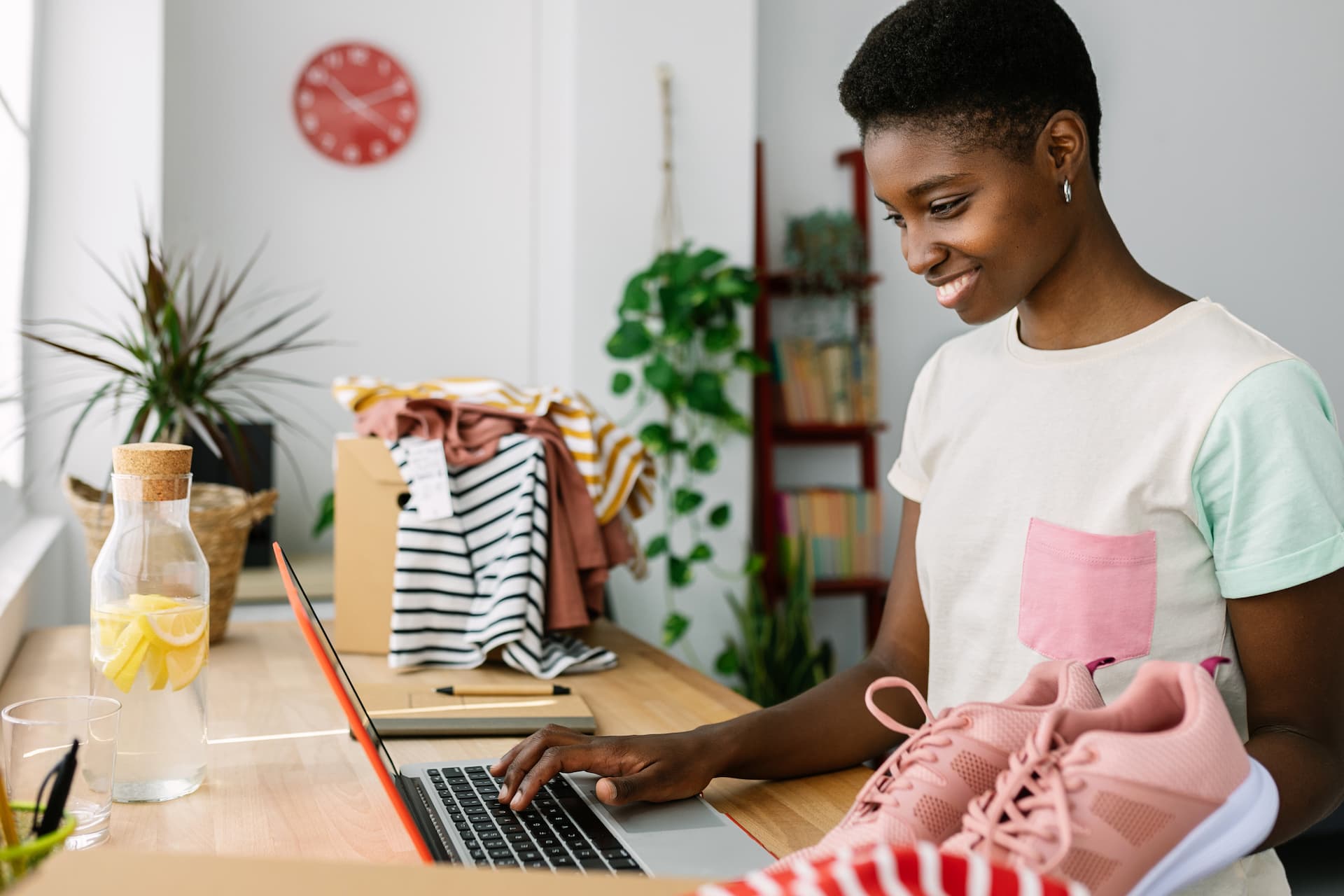 A smiling woman at home, happily shopping online using her laptop